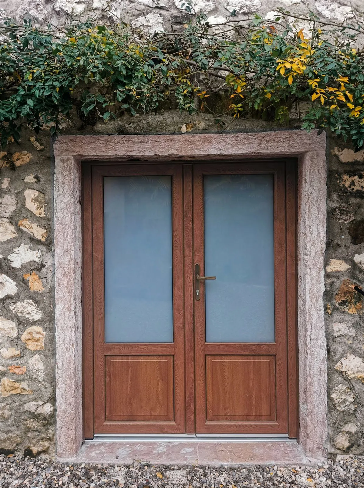 Portoncino a due ante effetto legno su casa in pietra